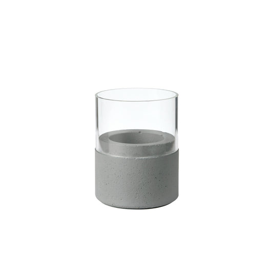 Der Kerzenhalter Glas Neat 70 x 61 mm von Duni GmbH zeichnet sich durch eine klare Glasplatte und einen hellgrauen Betonsockel mit glatten Oberflächen und klaren Linien aus, wodurch ein minimalistisches, modernes Wohnaccessoire entsteht.