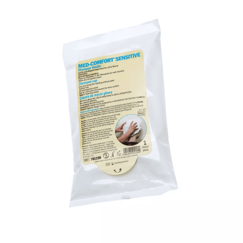 Una confezione in plastica bianca con la scritta «Cuffia per lo shampoo Med-Comfort con balsamo nutriente» della AMPri Handelsgesellschaft mbH. Sulla parte anteriore sono riportate le istruzioni e i dettagli in diverse lingue. Ideale per la cura delle persone allettate, contiene una cuffia monouso per lo shampoo Med-Comfort che garantisce un lavaggio igienico dei capelli. Lo sfondo è bianco.