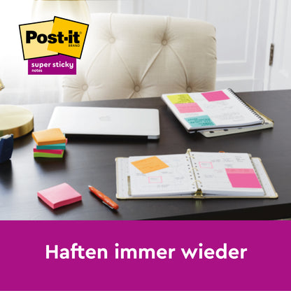 Ein Schreibtisch mit aufgeschlagenem Planer, Notizbüchern, bunten Post-it® Super Sticky Notes (76 mm x 127 mm, 90 Blatt/Block, 100% PEFC), einem geschlossenen Laptop, Stift, Lampe und einem Stapel Notizen. "Haften immer wieder" erscheint mit dem Logo der 3M Deutschland GmbH.