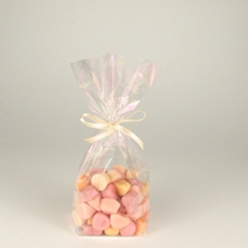 Un sacchetto Starpak 10, un sacchetto in PP trasparente, riempito con dolci rosa e beige e legato con un nastro chiaro, è posizionato al centro su uno sfondo semplice e chiaro.