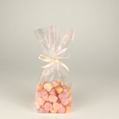Un sacchetto Starpak 10, un sacchetto in PP trasparente, riempito con dolci rosa e beige e legato con un nastro chiaro, è posizionato al centro su uno sfondo semplice e chiaro.