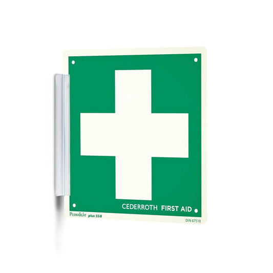 Ein grün-weißer "Clip signieren | Packung (1 Stück)" von Orkla Wound Care AB mit einem großen weißen Kreuz und dem Schriftzug "Cederroth First Aid" wird wie ein Signaturstempel mit einer Metallhalterung an der Wand befestigt und ist so am Arbeitsplatz gut sichtbar.