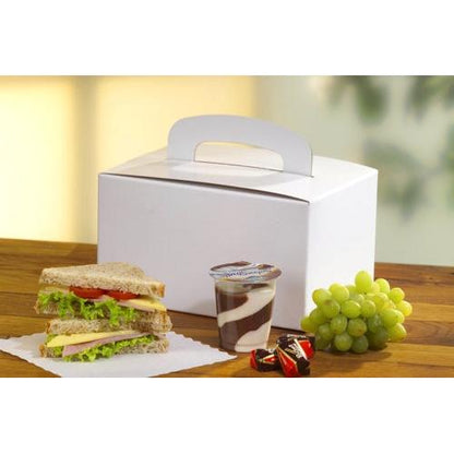 Una PAPSTAR 20 lunch-box in cartone ecologico (12,5x15,5x22,5 cm) con manico di PAPSTAR GmbH si trova su un tavolo di legno accanto a un panino, budino cioccolato-vaniglia, due cioccolatini e uva verde.