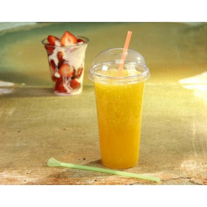 Ein Starpak 50 Trinkbecher "Hurricane", PET-Glasklar, mit gewölbtem Deckel und Strohhalm hält einen orangefarbenen Slush. Im Hintergrund steht ein weiterer Starpak Becher To-Go mit Erdbeeren und Sahne, daneben ein grüner Rührstab.
