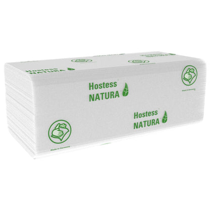 Una pila di asciugamani piegati bianchi Hostess™ NATURA™ (Kimberly-Clark GmbH), grandi, 20 x 84 fogli, con marchio verde e simbolo del pollice in su. Made in Germany - asciugamani di carta ideali per aree pubbliche. 20 pacchetti per cartone.