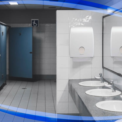 Un bagno pubblico con tre lavandini, uno specchio grande, porte delle cabine blu - una delle quali accessibile in sedia a rotelle - e pavimenti e pareti piastrellati bianchi dispone di un distributore Aquarius™ per asciugamani piegati di Kimberly-Clark GmbH sopra i lavandini.