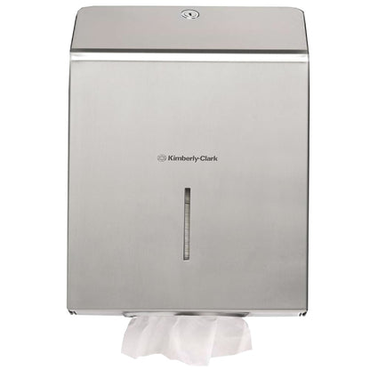 Il dispenser di asciugamani Kimberly-Clark Professional™ in acciaio inossidabile di Kimberly-Clark GmbH è montato a parete e garantisce un'asciugatura igienica delle mani con un asciugamano di carta bianco visibile nello scomparto di erogazione inferiore.