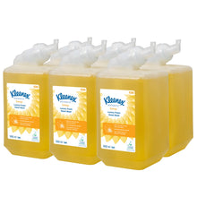 Sechs gelbe 1-Liter-Kassetten Kleenex® Botanics™ Luxury Foam Hand Wash der Kimberly-Clark GmbH sind in zwei Reihen angeordnet, jede mit einer weißen Pumpe und einem orange-weißen Etikett mit Branding und Produktinformation.