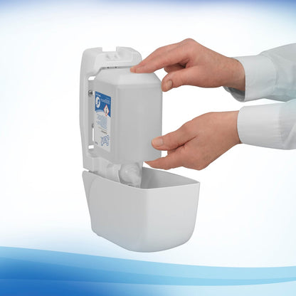 Una persona riempie un dispenser a parete con una cartuccia rettangolare da 1L di sapone schiumoso antibatterico Scott® di Kimberly-Clark GmbH. Il dispenser bianco, apribile frontalmente, aiuta a mantenere standard igienici ottimali nei bagni.
