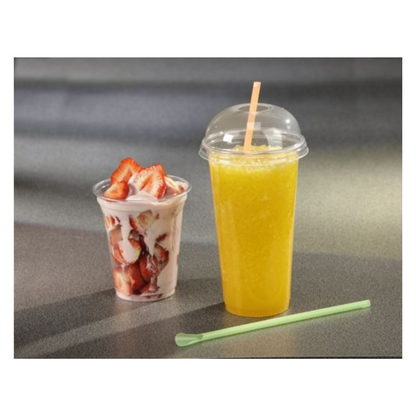 Ein Starpak 50 Trinkbecher "Hurricane" PET glasklar ist mit orangefarbenem Slush gefüllt und steht neben einem Plastikbecher mit Erdbeeren in Joghurt. Ein grüner Strohhalm liegt vor ihnen auf der grauen Oberfläche.