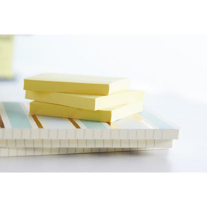 Tre pile di Post-it® Recycling Z-Notes (76x76 mm, 100 fogli/blocco, 100% PEFC) della 3M Deutschland GmbH riposano su due quaderni a righe in luce soffusa con uno sfondo delicatamente sfocato.
