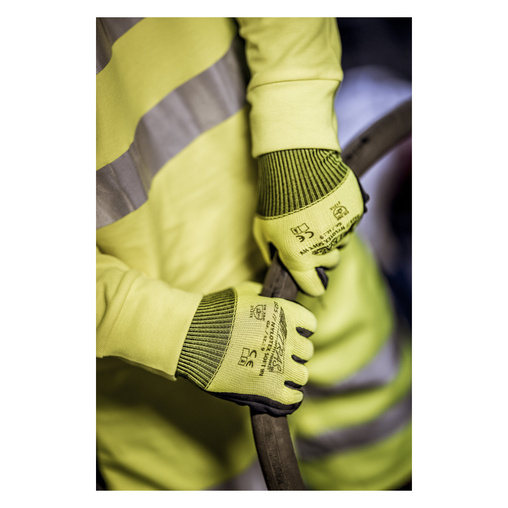 Una persona che indossa un giubbotto di sicurezza giallo e guanti in nylon NITRAS NYLOTEX SOFT HV della AS Arbeitsschutz GmbH, giallo neon, parzialmente rivestiti - con testo nero e simboli di sicurezza - tiene un cavo o un tubo spesso e scuro.