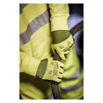 Una persona che indossa un giubbotto di sicurezza giallo e guanti in nylon NITRAS NYLOTEX SOFT HV della AS Arbeitsschutz GmbH, giallo neon, parzialmente rivestiti - con testo nero e simboli di sicurezza - tiene un cavo o un tubo spesso e scuro.