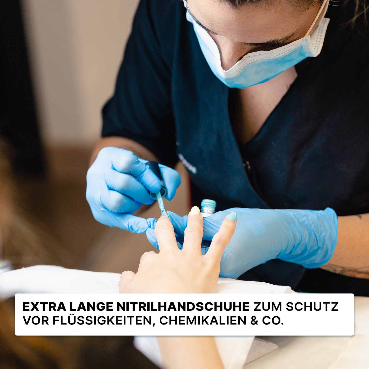Eine Person, die ARNOMED NITRIL BLUE XTRA LONG (30 cm) Einmalhandschuhe von ARNOWA GmbH und eine Maske trägt, lackiert jemandes Nägel; deutscher Text betont die schützende Funktion der blauen Nitrilhandschuhe.