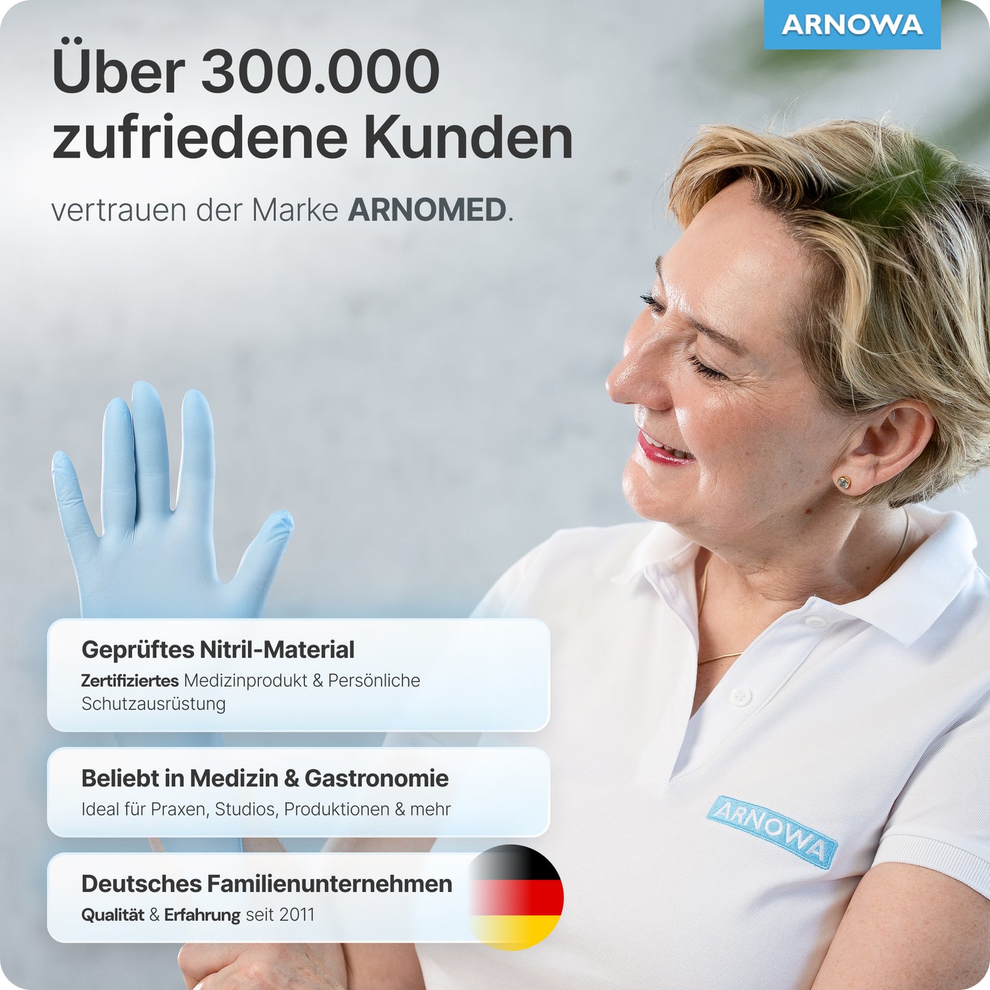 Una donna sorridente in un polo bianco ARNOWA tiene un guanto monouso ARNOMED NITRIL ICE BLUE. Il testo evidenzia oltre 300.000 clienti soddisfatti, materiale certificato privo di lattice e comprovata qualità tedesca della ARNOWA GmbH.