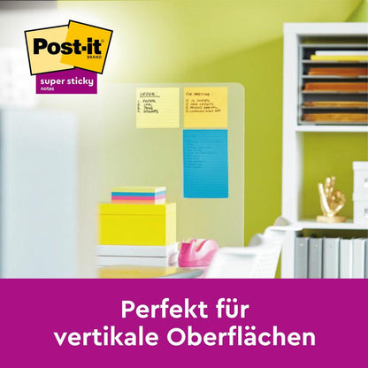 Una lavagna in vetro mostra tre Post-it® Super Sticky Notes in formato grande, rigati (102 mm x 152 mm, 45 fogli/blocco, 100% PEFC) di 3M Deutschland GmbH in ufficio. Testo: "Perfetto per superfici verticali." Logo del marchio Post-it visibile.