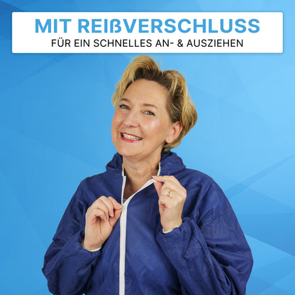 Una donna chiude la tuta monouso ARNOMED COVER PP-OVERALL BLUE con cappuccio in tessuto non tessuto PP di ARNOWA GmbH. Sopra di lei c'è il testo tedesco: "CON CERNIERA PER UNA RAPIDA VESTIZIONE E SVESTIZIONE" su sfondo blu.