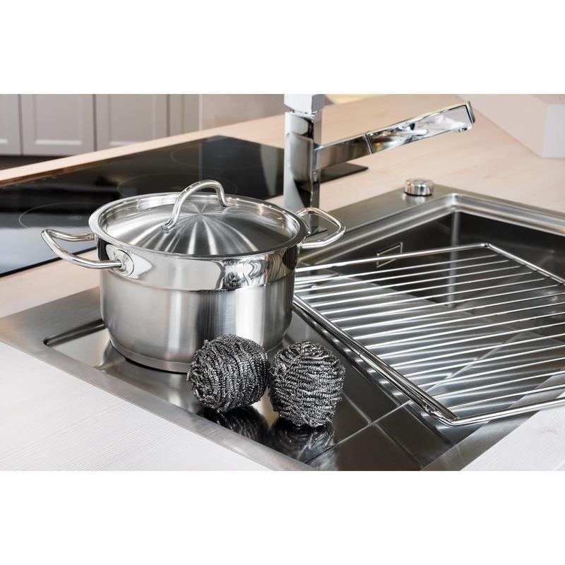 Una pentola in acciaio inossidabile con coperchio si trova nel lavandino accanto a due spirali in acciaio inossidabile Scotch-Brite® (3M Deutschland GmbH, 3 pezzi per confezione) e a un portapiatti - per una facile pulizia della cucina anche in presenza di sporco ostinato.