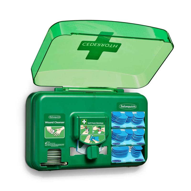 Un distributore di cure per ferite blu di Orkla Wound Care AB è aperto e mostra pacchetti per la pulizia delle ferite, cerotti e un rotolo di bende in schiuma morbida disposti in scomparti separati.