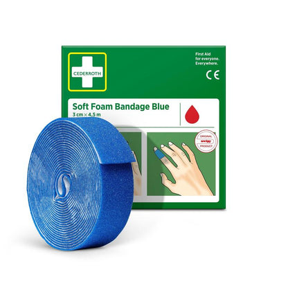 Un rotolo di Cederroth Soft Foam Bende blu 3x450cm di Orkla Wound Care AB è raffigurato davanti alla confezione verde-bianca, sulla quale la benda blu è avvolta intorno a un dito.