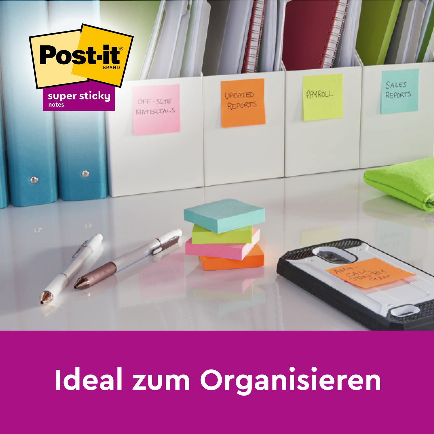 Ein Schreibtisch mit Mappen, beschriftet mit Post-it® Super Sticky Notes (verschiedene Farben, 76x76 mm, 45 Blatt/Block, 3 Blöcke, 100% PEFC) von 3M Deutschland GmbH, dazu Stifte, grünes Tuch, Smartphone auf Klemmbrett. Text: "Ideal zum Organisieren.