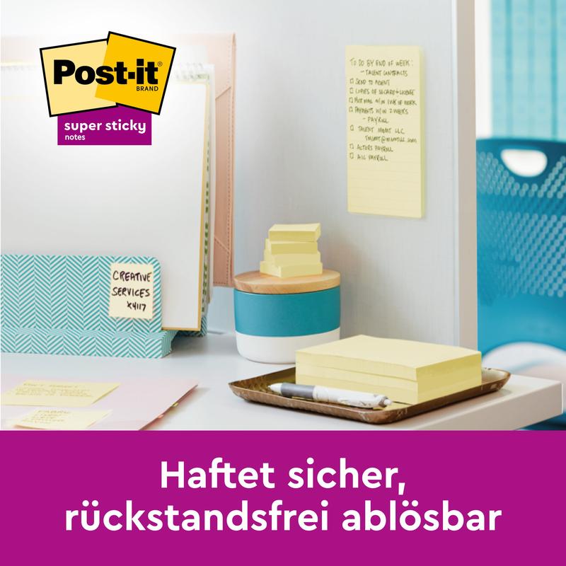Su una scrivania ci sono Post-it® Super Sticky 100% Recycling Notes (47,6 x 47,6 mm, 70 fogli/blocco, 100% PEFC) di 3M Deutschland GmbH, con una penna, cartelle e una nota sulla parete divisoria. Il logo appare; il testo in tedesco dice: "Aderisce in modo sicuro, si rimuove senza lasciare residui."