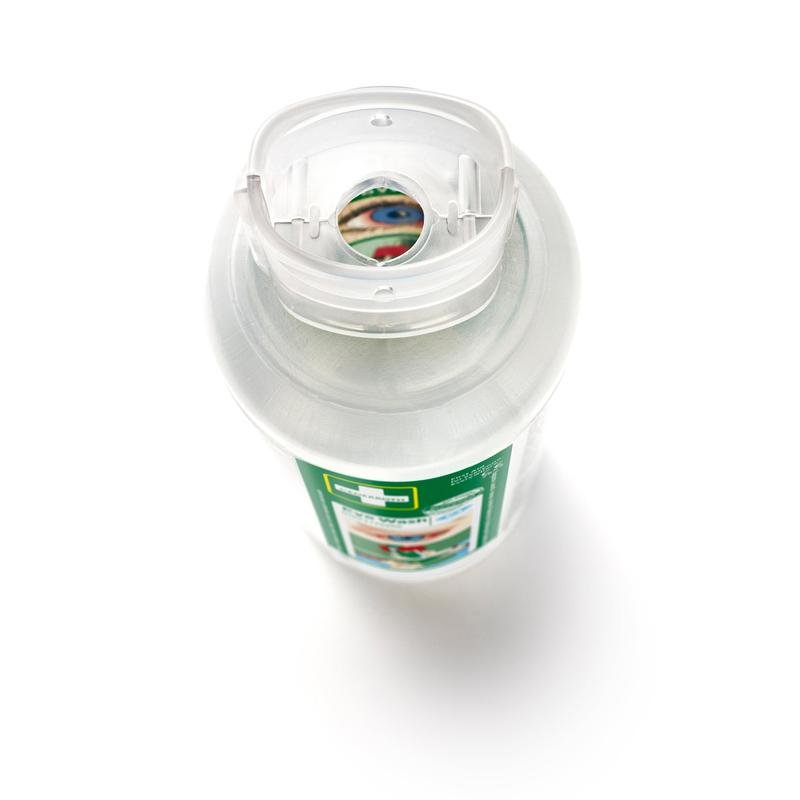 Primo piano di una bottiglia di lavaggio oculare Cederroth 2 x 500 ml (confezione da 2) di Orkla Wound Care AB dall'alto, con tappo flip-top trasparente ed etichetta verde-bianca che indica l'uso in caso di incidenti agli occhi. Una parte dell'etichetta è visibile attraverso l'apertura del tappo.
