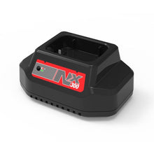 Un caricabatterie NX rettangolare nero di Diversey Deutschland GmbH & Co. OHG, etichettato "NX 300", con spia di controllo e vano batteria, per la macchina per la pulizia TASKI swingo 250µicro, inclusi cavi EU/UK/SEV; raffigurato su sfondo bianco.