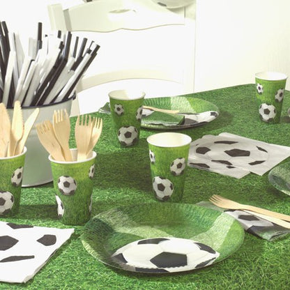Una tavola da festa è apparecchiata con PAPSTAR tovaglioli a 3 veli da calcio (20 tovaglioli, 33x33 cm, Design Set 4), cannucce a righe bianco e nero, posate in legno in un portaposate e una tovaglia verde a forma di prato. Marca: PAPSTAR GmbH.