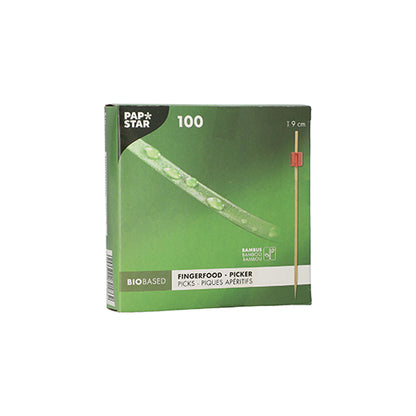 La scatola verde "PAPSTAR 100 Fingerfood - Picker" della PAPSTAR GmbH contiene 100 bastoncini di bambù di 9 cm ciascuno. La confezione biobased mostra un bastoncino con punta rossa, ideale per servire spiedini di fingerfood in ogni evento.
