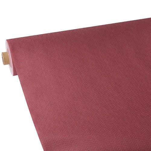 Un rotolo di tovaglia Starpak, simile al tessuto, tessuto non tessuto "soft selection plus" di Starpak in una tonalità strutturata rossastra-marrone viene parzialmente srotolato su uno sfondo bianco, mettendo in risalto la struttura della superficie e il colore del materiale.