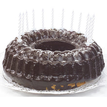 Una torta al cioccolato con glassa lucida, decorata con candele di compleanno PAPSTAR GmbH di 6 cm, bianche con supporto (24 pezzi), distribuite uniformemente lungo il bordo e posizionate su un centrino bianco.