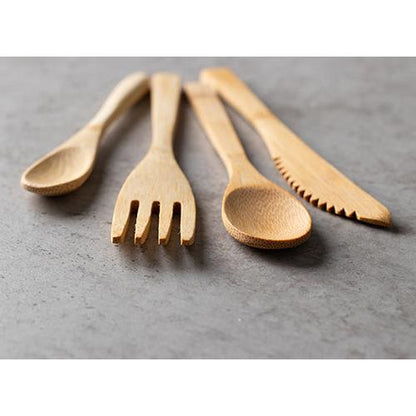 Quattro utensili di legno - un cucchiaio, una forchetta, un altro cucchiaio e un PAPSTAR coltello di bambù "pure" 16 cm - sono disposti su una superficie di pietra grigia. I coltelli monouso ecologici della PAPSTAR GmbH sono color marrone chiaro e hanno una superficie liscia e lucida.
