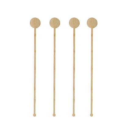 Quattro PAPSTAR 100 fruste per bevande in bambù "pure" del marchio PAPSTAR GmbH con teste rotonde e piatte sono disposte verticalmente in fila su uno sfondo bianco.