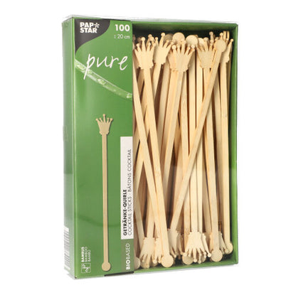 Una confezione con 100 PAPSTAR fruste per bevande da 20 cm in bambù biodegradabile, a forma di corona, parzialmente visibili attraverso la finestra trasparente. La confezione riporta il logo della PAPSTAR GmbH.