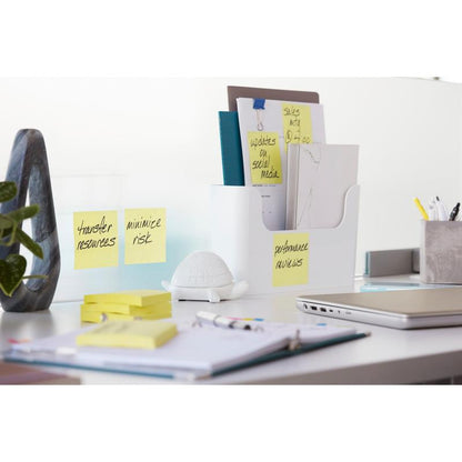 Una scrivania ordinata con raccoglitori, 3M Deutschland GmbH Post-it® Super Sticky Notes (Giallo, 76x127mm, 90 fogli/blocco, 14+2 confezione promo), un laptop, penne, una pianta, una decorazione a forma di tartaruga bianca e un taccuino. Sulle note c'è scritto: "Trasferire risorse", "Minimizzare il rischio", "Valutazione delle prestazioni".