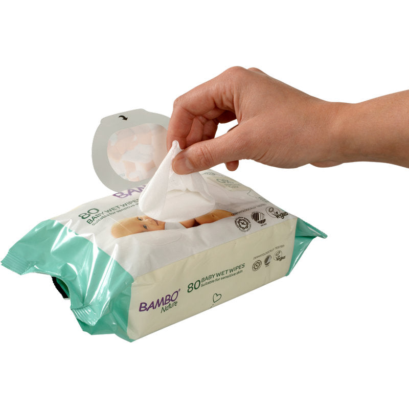 Eine Hand zieht ein Bambo Nature Feuchtpflegetuch m. Klebeverschluss (15x20cm, 80 Stück) von Abena Re-Seller GmbH aus seiner hellgrün-weißen Verpackung, die für empfindliche Babyhaut mit Icons und Text auf der Vorderseite gestaltet ist.
