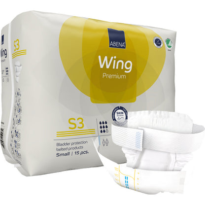 Eine aufrecht stehende Packung ABENA Wing Premium der Abena Re-Seller GmbH wird mit einer Gürtelwindel davor präsentiert. Die Packung enthält 15 kleine Teile, die Schutz und Komfort für einen zuverlässigen Blasenschutz bieten.