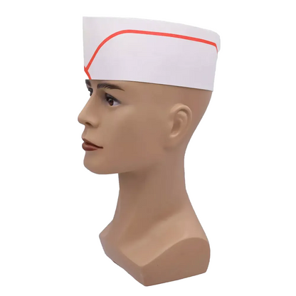 Una testa di manichino presenta la cuffia AMPri, un classico cappello di carta in stile diner con una striscia rossa, concepito come prodotto monouso. Questo copricapo regolabile della AMPri Handelsgesellschaft mbH si adatta perfettamente quando il manichino guarda a sinistra, e con il suo fascino senza tempo ricorda le uniformi dei fast-food.