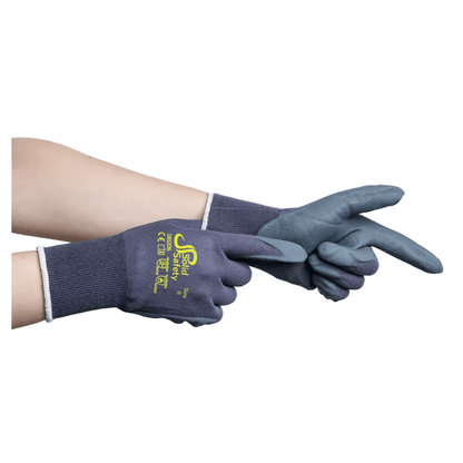 Un paio di mani che indossano guanti da montaggio ultraleggeri AMPri SolidSafety Tough Micro Touch di colore grigio scuro, con testo e loghi gialli sul dorso. I guanti hanno un polsino in tessuto e una texture in micro schiuma di nitrile sul palmo e sulle dita. Una mano indica, mentre l'altra sistema il guanto.