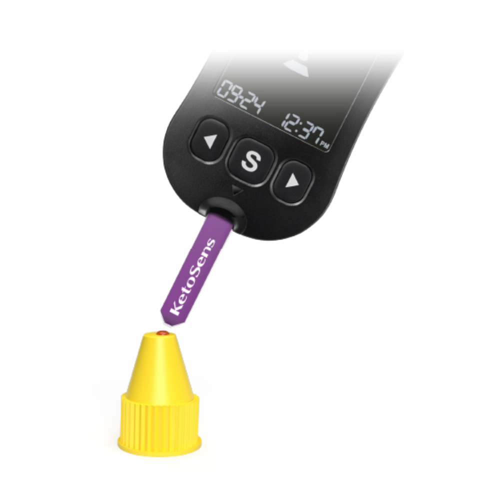 Un dispositivo di misurazione digitale con un display che mostra „09:24“ e „12:37 Uhr“ viene utilizzato per testare una striscia viola con la scritta „Alphacheck KetoSens β-Keton-Soluzione di controllo L+M | Confezione (2 flaconcini)“. La striscia Alkacheck Alphacheck KetoSens β-Keton-Soluzione di controllo L+M | Confezione (2 flaconcini) punta verso un piccolo tappo giallo. Il dispositivo è dotato di un grande pulsante „S“ sotto il display.