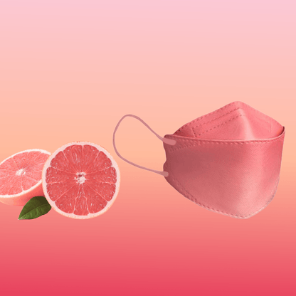 Una maschera facciale designer Altruan filtrante particelle (standard FFP2) è elegantemente posizionata accanto a due metà di pompelmo su uno sfondo rosa sfumato, sottolineando il suo design elegante e la sua vestibilità ergonomica.