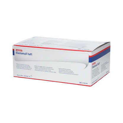 Una scatola di BSN Elastomull® haft, una benda elastica bianca della BSN Medical GmbH, è esposta. La confezione presenta accenti blu e rossi che evidenziano l'etichetta come benda elastica di fissaggio. Il testo sulla scatola contiene informazioni sul prodotto e specifiche in diverse lingue.