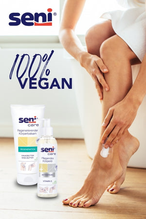 Anzeige von Seni Care Produkten: 100% VEGAN. Zu sehen sind eine Tube mit regenerierendem Körperbalsam und eine Sprühflasche mit regenerierender Körperpflege, die auf einer Fußhaut aufgetragen werden.