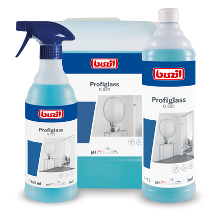 L'immagine mostra tre contenitori con il detergente per vetri e superfici pronto all'uso Buzil Profiglass G 522 di BUZIL-WERK Wagner GmbH & Co. KG, a sinistra una bottiglia spray, dietro una caraffa a gallone e a destra una bottiglia alta. Ogni contenitore è dotato di un'etichetta blu che evidenzia la capacità del detergente di creare una lucentezza senza striature e di rimuovere i residui grassi dalle superfici di vetro.