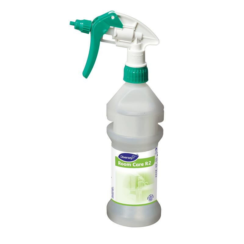 Una chiara bottiglia spray Room Care R2 Plus Pur-Eco vuota di Diversey Deutschland GmbH & Co. OHG con un ugello di spruzzo verde e bianco si trova in piedi su uno sfondo bianco semplice.