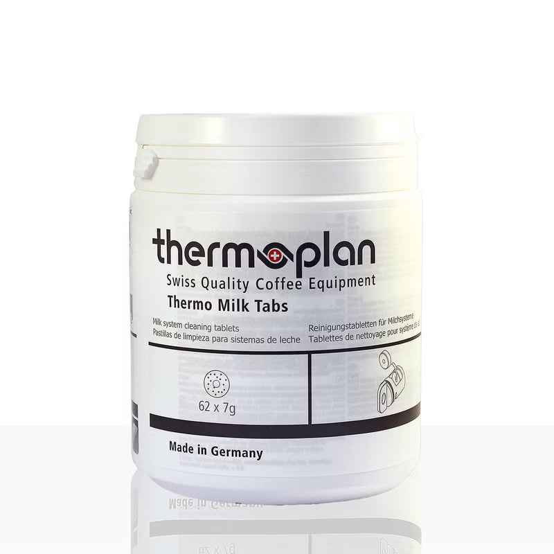 Un contenitore di plastica bianca con la scritta "Thermoplan Thermo Milk Tabs, compresse di pulizia per macchine da caffè espresso | Confezione (62 pezzi)" di Diversey Deutschland GmbH & Co. OHG, per la pulizia igienica, mostra "62 x 7g", "Made in Germany" e informazioni in più lingue.