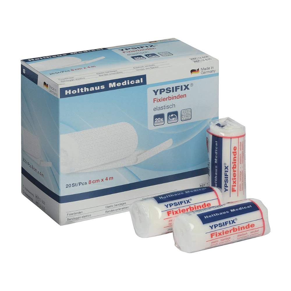 Immagine di una scatola di bendaggi di fissaggio Holthaus Ypsifix® di Holthaus Medical GmbH & Co. KG, 8 cm x 4 m. La scatola contiene 20 bende singole. Tre bende singole sono raffigurate sulla parte anteriore della scatola; due sono sigillate in plastica, mentre una è parzialmente scartata. Prodotto in Germania, perfetto per fissare le medicazioni.