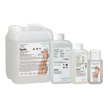 Sono raffigurate quattro bottiglie trasparenti della Kiehl Opydes Igienico Disinfezione delle Mani della Johannes Kiehl KG in diverse dimensioni in fila. Portano una scritta bianca e blu con simboli delle mani per la disinfezione igienica delle mani e la riduzione dei germi.