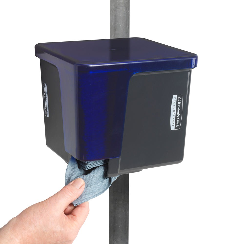 Una persona estrae un panno igienico da un distributore di salviette Kimberly-Clark Professional™ grigio - piegato in quarti di Kimberly-Clark GmbH, fissato a un'asta di metallo verticale.